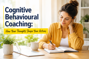 Woman writing in a notebook at a bright desk with the title Cognitive Behavioural Coaching: How Your Thoughts Shape Your Actions