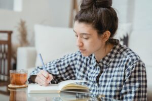 Person journalling at a desk while reflecting on a personal problem.